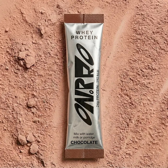 ON.PRO chocolate whey protein sachet on a bed of powder